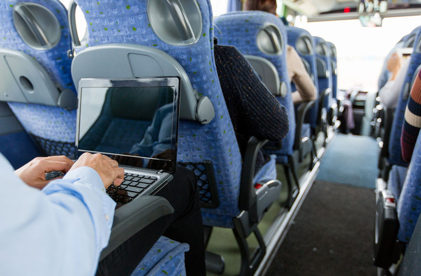 man with smartphone and laptop in travel bus